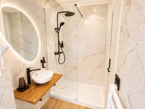 a bathroom with a sink and a shower at MRODBNB - Appart Neuf - Aperçu Mer - 25m Plage & Resto - Ciné - Cheminée - Popcorn in Cancale
