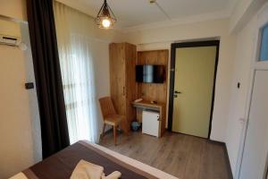 una camera da letto con un letto, una scrivania e una televisione di ida efes a Selçuk Altre 19 foto