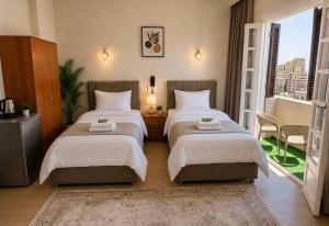 a bedroom with two beds and a window at New Hyde Park House Hotel in Alexandria