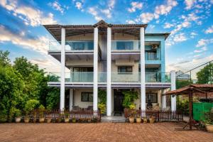 a white building with a fence in front of it at Nirvana Inn in Mahabaleshwar