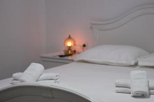 a bedroom with a white bed with towels on it at A&B Berat in Berat