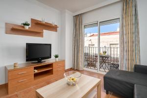 a living room with a tv and a couch at Apartamentos Nerjaluna in Nerja