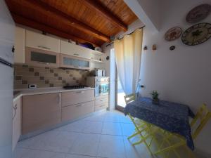 a kitchen with a table and a clock on the wall at millennium holiday in Castellammare del Golfo
