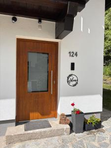 a wooden door on a house with two plants at Irmas Ferienhäusl in Längenfeld
