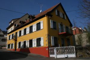 a yellow and orange building with a balcony at Lina et Anaë in Saint-Nabor