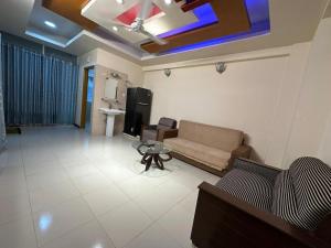 a living room with a couch and a table at Vacation House a Service Apartment in Cox's Bazar