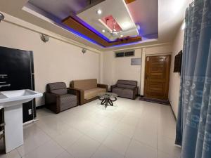 a living room with a couch and a table at Vacation House a Service Apartment in Cox's Bazar +4 photos
