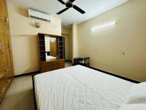 a bedroom with a bed and a ceiling fan at Vacation House a Service Apartment in Cox's Bazar