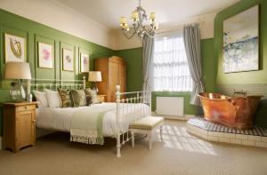 a bedroom with green walls and a bed and a tub at The Royal Lion Hotel in Lyme Regis +96 photos