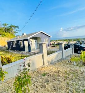 a house with a fence in front of it at Jamaica Coastal Getaway in Discovery Bay