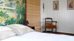 a bedroom with a bed and a chair in it at Lina et Anaë in Saint-Nabor