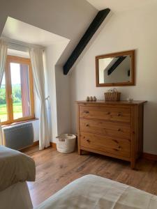 a bedroom with a wooden dresser and a mirror at Ty Job in Langoëlan +27 photos