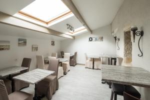 a dining room with tables and chairs and a skylight at Hôtel Le Peu Breton in Sainte-Marie-de-Ré