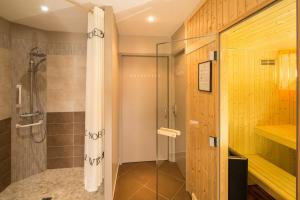 a shower with a glass door in a bathroom at Hôtel Le Peu Breton in Sainte-Marie-de-Ré