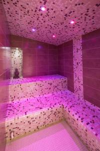 a purple bathroom with pink lights on the wall at Hôtel Le Peu Breton in Sainte-Marie-de-Ré