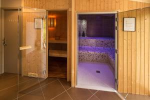 a walk in shower with a purple floor in a room at Hôtel Le Peu Breton in Sainte-Marie-de-Ré