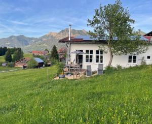 a white house in a field of green grass at Chalet Alpenlicht in Oberstdorf