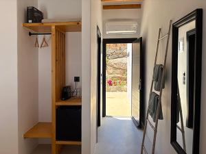 a hallway with a door leading to a room with a window at CHARMA Mykonos in Kalo Livadi