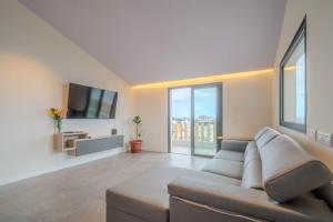a living room with a couch and a flat screen tv at Villa Vista Suite by Aura Collection in Tamaduste