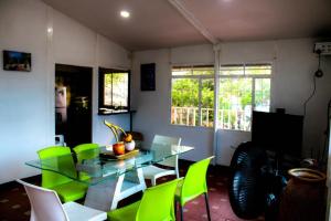 a dining room with a glass table and green chairs at La melosa in Girardot