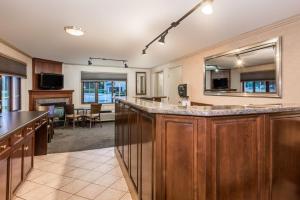 a large kitchen with a bar and a living room at Super 8 by Wyndham Guelph in Guelph