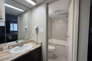 a bathroom with a sink and a toilet and a mirror at Super 8 by Wyndham Guelph in Guelph +21 photos