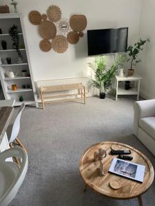 a living room with a coffee table and a couch at 2 bed- walkable train and beach apartment in Crosby