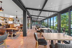 ein Restaurant mit Tischen, Stühlen und Fenstern in der Unterkunft Hotel Vali Dramalj in Crikvenica + 47 Fotos