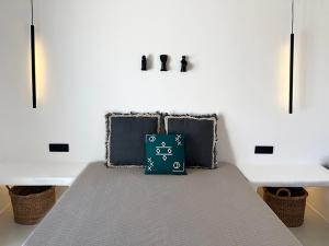 a bed with a green bag sitting on top of it at CHARMA Mykonos in Kalo Livadi