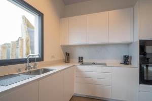 a white kitchen with a sink and a window at Villa Vista Suite by Aura Collection in Tamaduste +37 photos