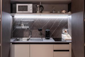 a kitchen with a sink and a microwave at Ambrosia Room & Apartment in Rossano +95 photos