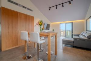 a living room with a wooden table and white chairs at Villa Vista Suite by Aura Collection in Tamaduste