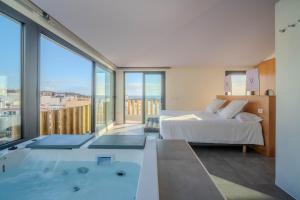 a bedroom with a tub and a bed and a large window at Villa Vista Suite by Aura Collection in Tamaduste