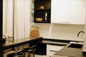 a kitchen with white cabinets and a black counter top at The ALL-in-ONE LOFT with AIRPORT pickup in Ulaanbaatar