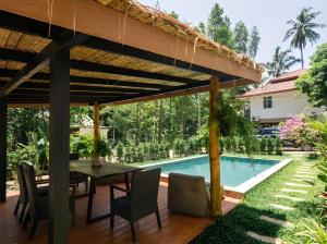 a patio with a table and chairs and a swimming pool at Villa Vista in Wok Tum