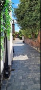 an empty driveway with a brick wall and a building at 2 bed- walkable train and beach apartment in Crosby +5 photos