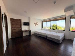 a bedroom with two beds and a large window at Hotel La Mar Playas in Playas