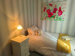 a bedroom with a bed and a table with a lamp at Waterloo Cottage in Barnard Castle