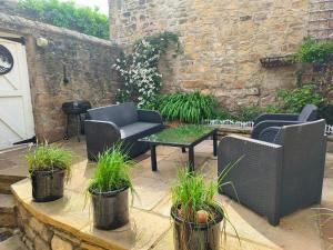 a patio with chairs and a table with plants at Waterloo Cottage in Barnard Castle