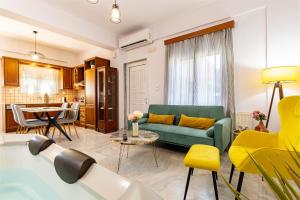 a living room with a green couch and a table at Achilleas Deluxe House-Jacuzzi - BBQ in Kotsianá