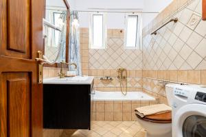 a bathroom with a tub and a sink and a toilet at Achilleas Deluxe House-Jacuzzi - BBQ in Kotsianá +36 photos