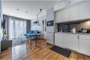 a kitchen with white cabinets and a table in a room at Mechelinki Enjoy in Mechelinki