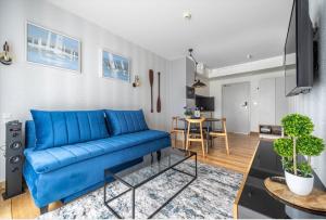 a living room with a blue couch and a table at Mechelinki Enjoy in Mechelinki