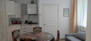 a kitchen with a table and a couch and a door at GGG FLAT a in Dobrovelychkivka