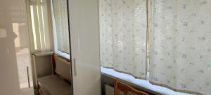 a room with a window with a curtain and a stair case at GGG FLAT a in Dobrovelychkivka
