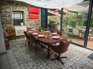 a dining room with a wooden table and chairs at Les Boissèdes in Les Vans