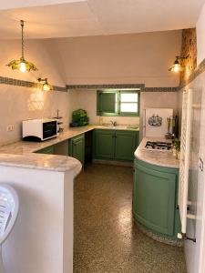 a kitchen with green cabinets and a counter top at Casa Giallo Kelibia - Traditional charm in Kelibia
