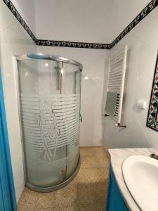 a bathroom with a glass shower with a sink at Casa Giallo Kelibia - Traditional charm in Kelibia +2 photos