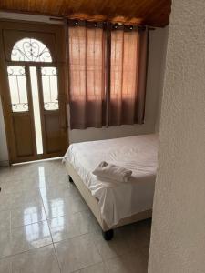 a bedroom with a bed and a window and a door at El Palmar in Palmira