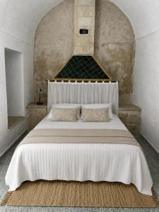 a bedroom with a large white bed with two pillows at Casa Giallo Kelibia - Traditional charm in Kelibia
